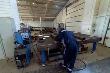 Fototapeta premium Industrial welder on workplace. Worker in helmet welding.