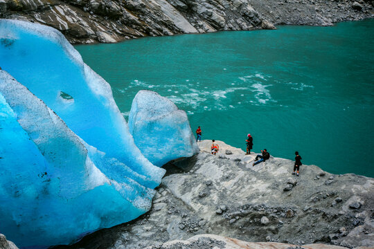 Tourists and a glacier in the mountains, Norway.Thirst for adventure and the best photo, despite the danger.