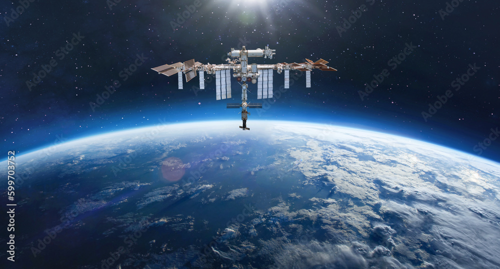 Fototapete International Space station on orbit of Earth. Space wallpaper with ISS and planet surface in deep outer space. Stars in space. Astronauts in space. Elements of this image furnished by NASA