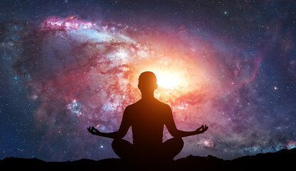 Silhouette of human sitting on stars background. Meditation in yoga. Psychology and relax