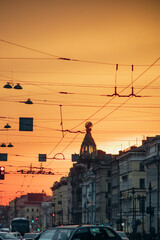 Bright orange sunset on the avenue in a large old city.