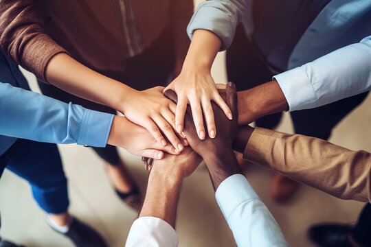Closeup shot of a group of unrecognizable business people joining their hands together in a huddle