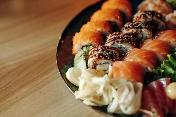 Foto op Plexiglas Mixed Sushi Set nigiri, rolls and sashimi served in traditional Japan black Sushioke round plate. © Дмитрий Скорина