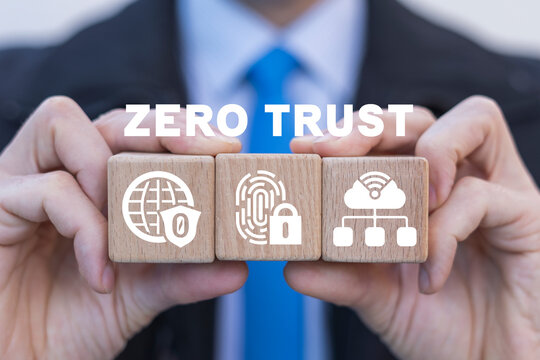 Businessman holding wooden cubes with icons and sees inscription: ZERO TRUST. Concept of zero trust security network.