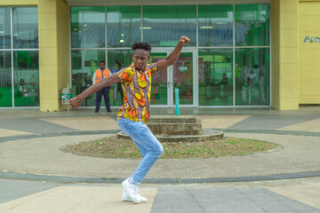 Joven Afrodescendiente baila al estilo urbano en el centro de la ciudad usando atuendos coloridos