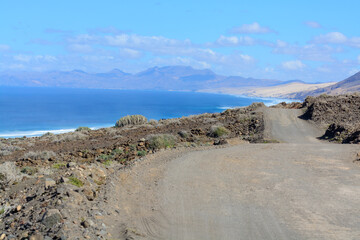 View on difficult to access golden sandy Cofete beach hidden behind mountain range on Fuerteventura, Canary islands, Spain