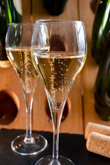 Glasses of sparkling white wine champagne or cava with bubbles and classic wooden champagne pupitre...