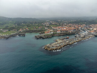 Fototapeta premium Aerial view on Playa de Toro and Llanes old harbour, Green coast of Asturias, North Spain with sandy beaches, cliffs, hidden caves, green fields and mountains.