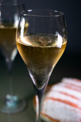 Glasses of sparkling white wine champagne or cava with bubbles and sweet dessert Reims rose biscuits on background