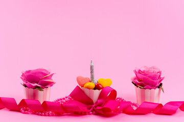 a front view designed pink presents with flower and candle on the pink background beauty color present birthday