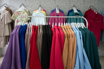 Women's dresses on hangers in a retail shop. Row of different female clothes hanging on rack in fashion show room