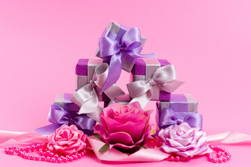 a front view little purple boxes with little designed flowers on the pink background present gift birthday celebration