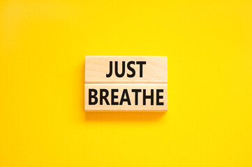 Just breathe and psychological symbol. Concept words Just breathe on beautiful wooden block. Beautiful yellow table yellow background. Business psychological and Just breathe concept. Copy space