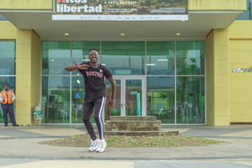 Fototapeta na wymiar Hombre afro de edad madura baila al estilo urbano en el centro de la ciudad
