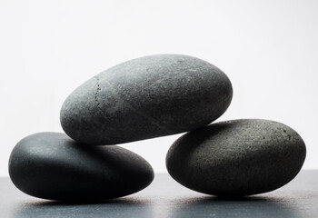 Fototapeta na wymiar gray zen stones on a dark gray background with shadows for a podium background.a group of oval stones for product presentation