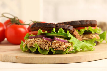 Delicious sandwiches with tuna and vegetables on white table. closeup