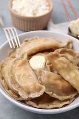 Delicious dumplings (varenyky) with cottage cheese and butter served on table, closeup