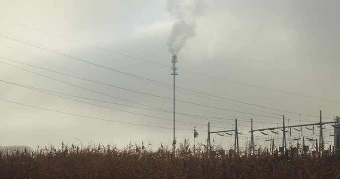 Chimney fumes and smoke in the middle of a field 4K