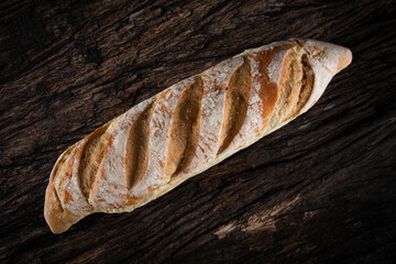 Fresh homemade rustic sourdough bread on a rustic wood background