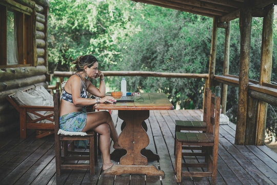 Mujer trabajando con una notebook en una caba&ntilde;a