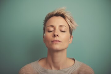 Fototapeta premium Portrait of young woman with closed eyes on a blue background.