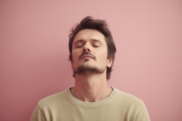 Obraz premium Portrait of a young man with closed eyes on a pink background
