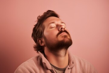 Obraz premium Portrait of a young man with closed eyes on a pink background