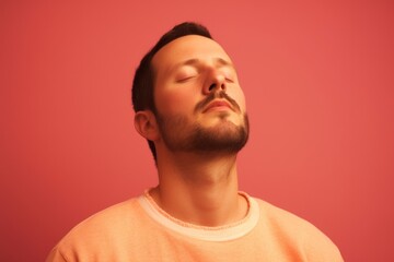 Obraz premium Portrait of a handsome young man with closed eyes on a red background