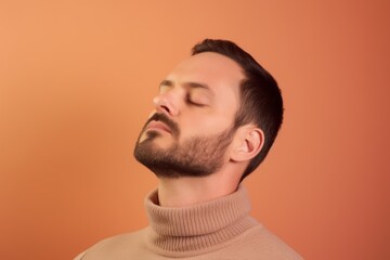 Obraz premium Portrait of a young man with closed eyes on a orange background