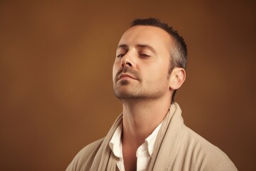 Obraz premium Portrait of a handsome young man with closed eyes on brown background