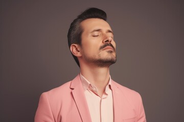 Obraz premium Medium shot portrait photography of a man in his 30s practicing mindfulness, sophrology, relaxation & stress-reduction wearing a classic blazer on pastel background. Generative AI