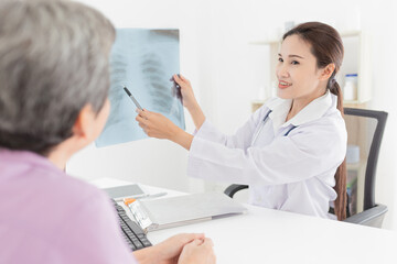 Asian doctor looking patient film, she talk with patient and explain about disease, broken bone treatment, tuberculosis screening