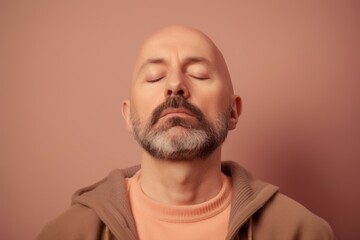 Obraz premium Portrait of a bald man with a beard on a pink background