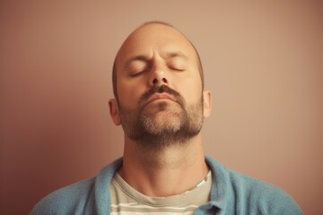 Obraz premium Portrait of a bald man with closed eyes on a pink background