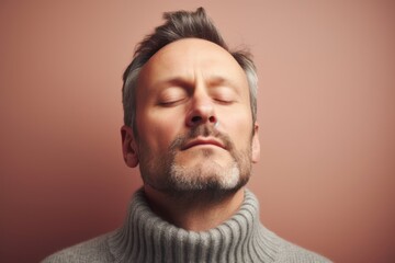 Obraz premium Portrait of a man with closed eyes on a pink background.