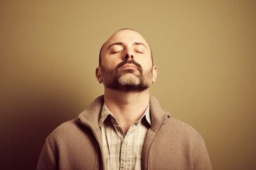 Obraz premium Portrait of a young man with closed eyes on a brown background. Toned.