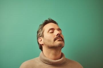 Obraz premium Young man with closed eyes on a green background. Toned.