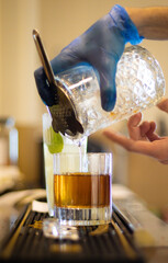 The bartender pouring a cocktail drink