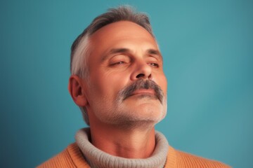 Obraz premium Portrait of a middle-aged man on a blue background.