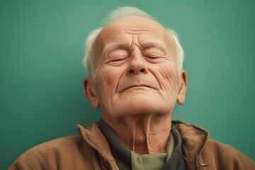 Fototapeta premium Portrait of an elderly man on a green background. Toned.