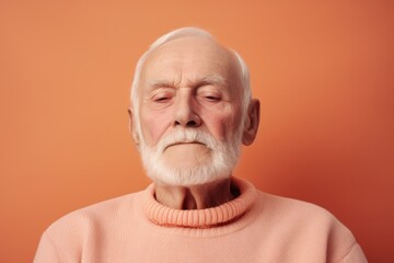 Portrait of an old man with a white beard on an orange background