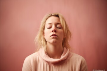 Blonde woman with closed eyes on pink background. Portrait of a girl with closed eyes.