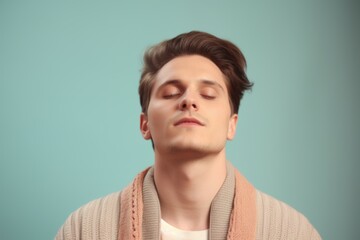 Portrait of a handsome young man with closed eyes on blue background
