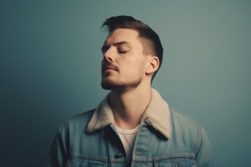 Young man in denim jacket on a blue background. Toned.