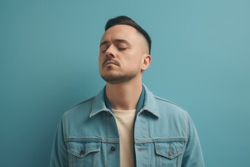 Obraz premium Portrait of a young man in a denim jacket on a blue background