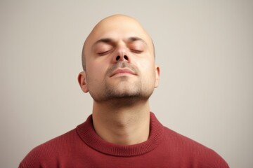 Fototapeta premium Portrait of a bald man with closed eyes on a gray background