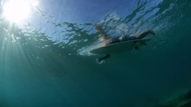 Slow Motion Shot Of Man Swimming With Surfboard Seen From Undersea - Oahu, Hawaii