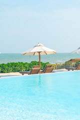 umbrella with bed pool around swimming pool with ocean sea background