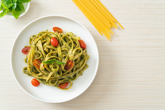 fettuccine spaghetti pasta with pesto sauce and tomatoes