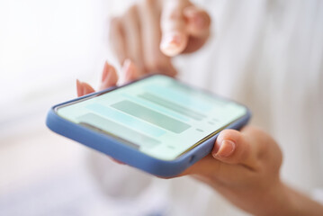 スマートフォンでメッセージのやりとりをする女性の手元